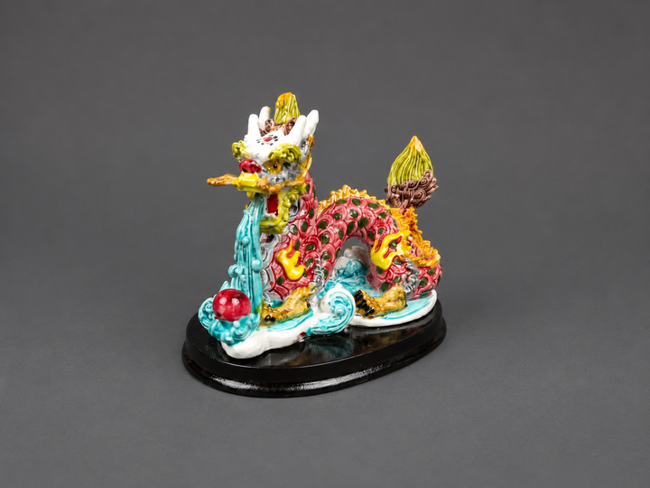 Colourful Feng Shui Dragon figurine with flowing water and pearl details, displayed on a black base for prosperity, protection and positive energy décor.